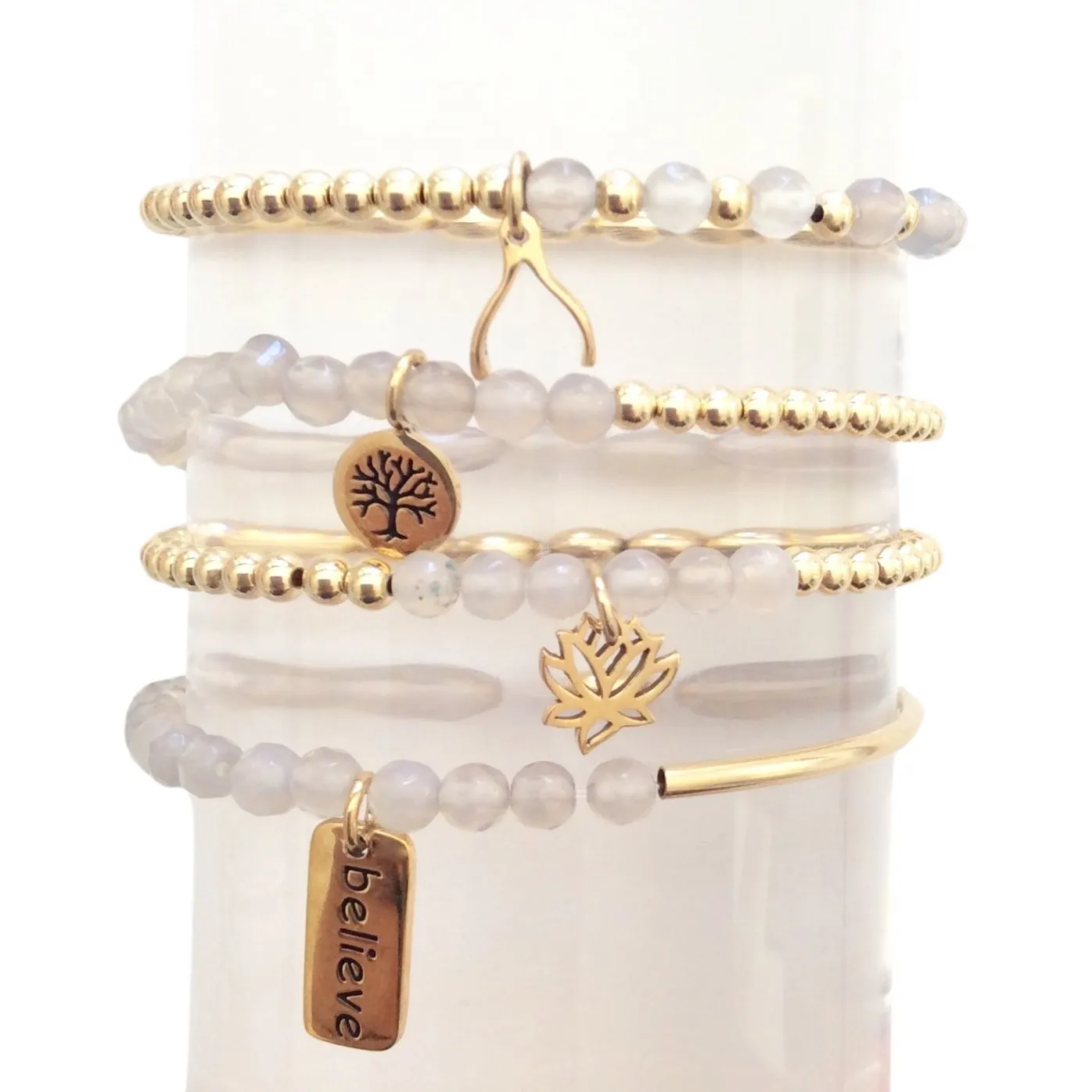 Dainty Set of Four Beige and Gold Faceted Beaded Bracelets with Lotus and Om Charms - Wholesale